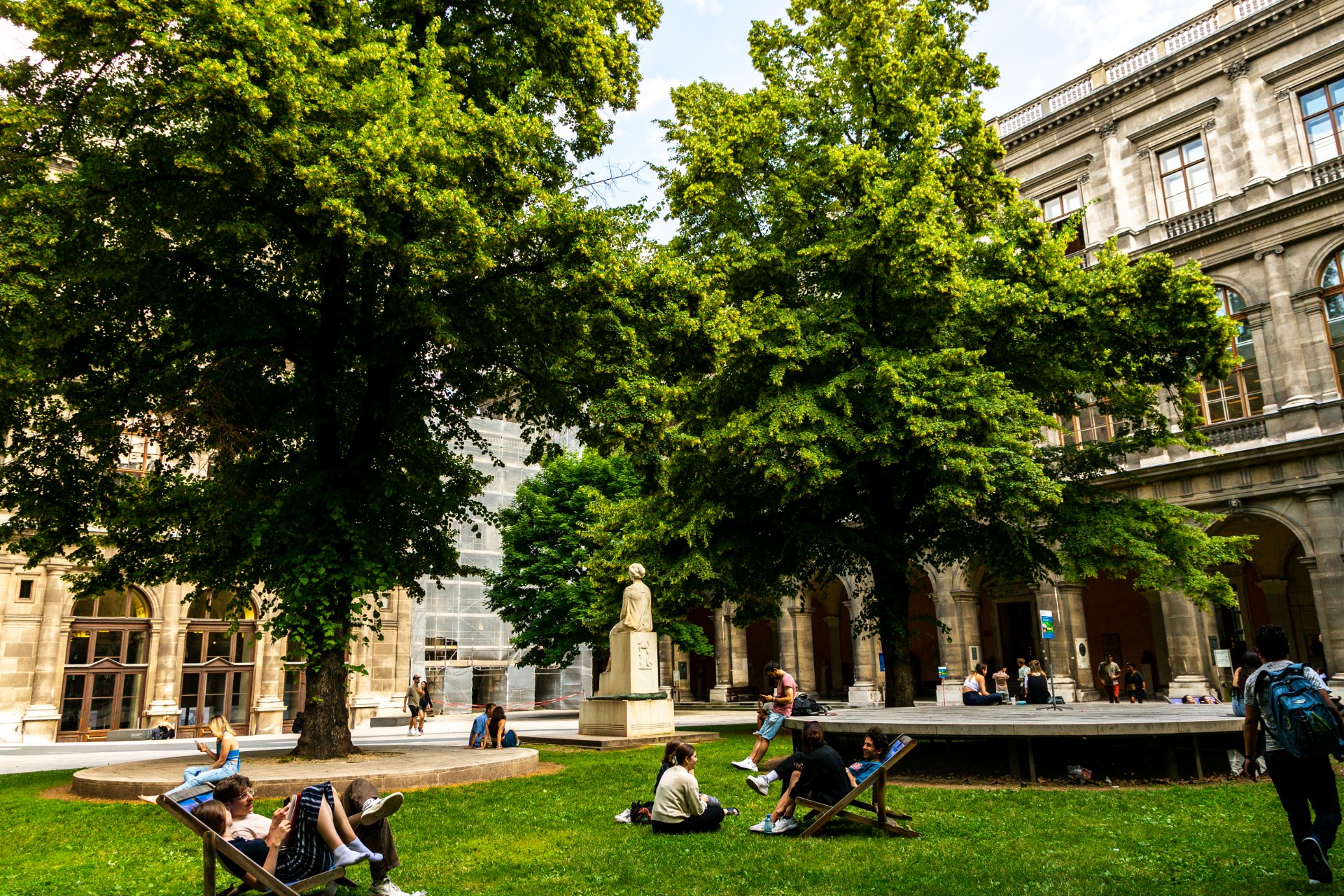 Studierende entspannen im Arkadenhof der Universität Wien